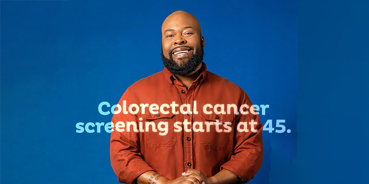 A man stands with hands clasped against a dark blue background and the words: Colorectal cancer screening starts at 45.