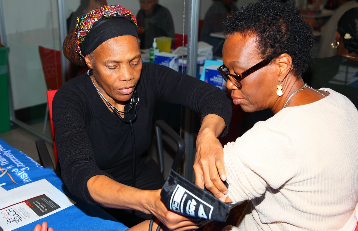 A Wellness Center staff member checks a woman's blood pressure