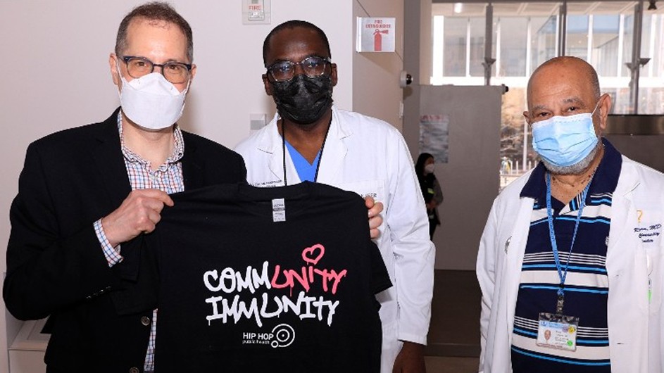 Three ColumbiaDoctors healthcare providers attend the vaccine pop-up; one holds a T-shirt that reads "community immunity."