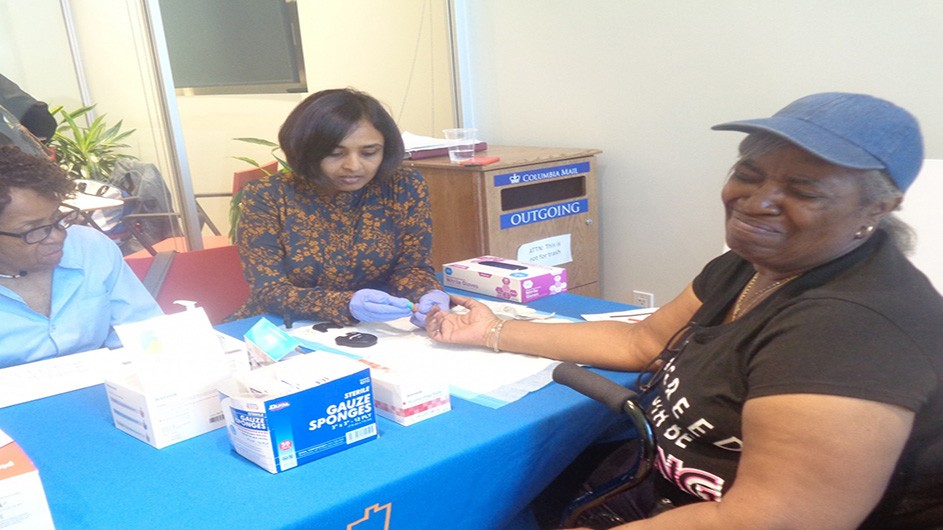 InTOuCH Program Manager, Janhavi, performs an A1C screening on a CHW from Cohort 9.